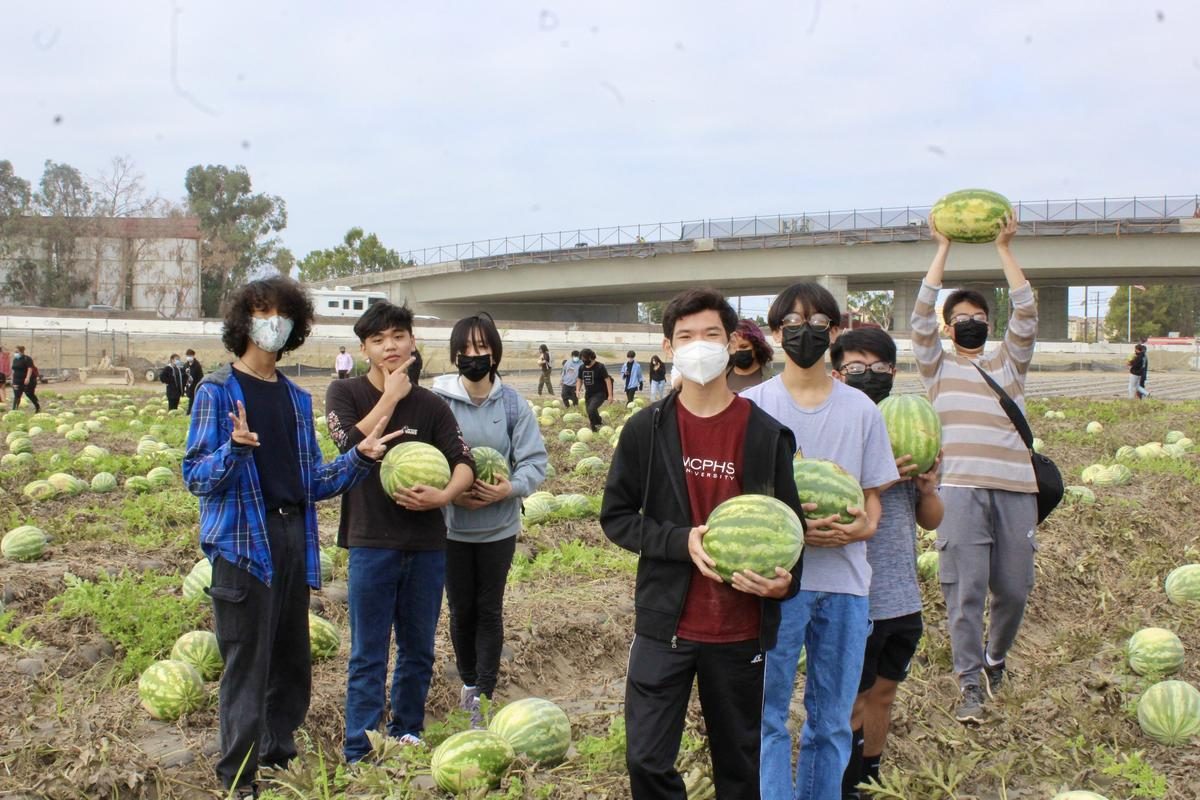 Students proudly holding watermelons they harvested
