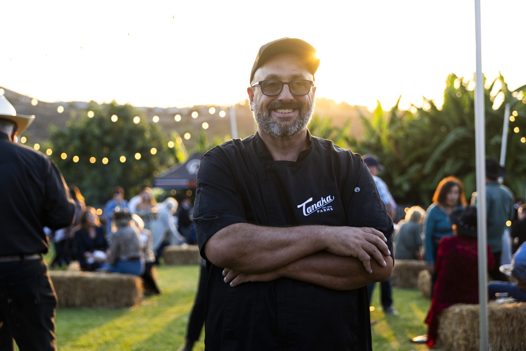 A smiling chef at golden hour during the Harvest Moon dinner